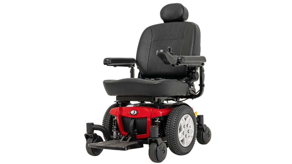 A Jazzy 600ES Power Wheelchair with a black cushioned seat, armrests, headrest, footplate, a red base, large rear wheels, and two smaller front wheels.