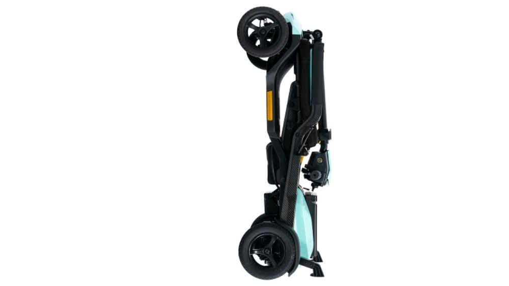 A folded Go Go Super Portable 4-Wheel Scooter stands upright, displaying its compact design with black and teal accents and four visible wheels.