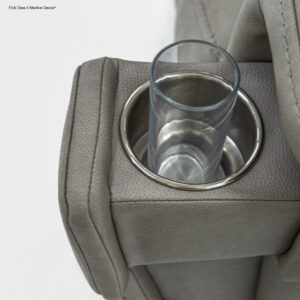 A clear glass rests in a stainless steel cup holder set into the light gray upholstered armrest of the VivaLift! Ultra Lift Chair.