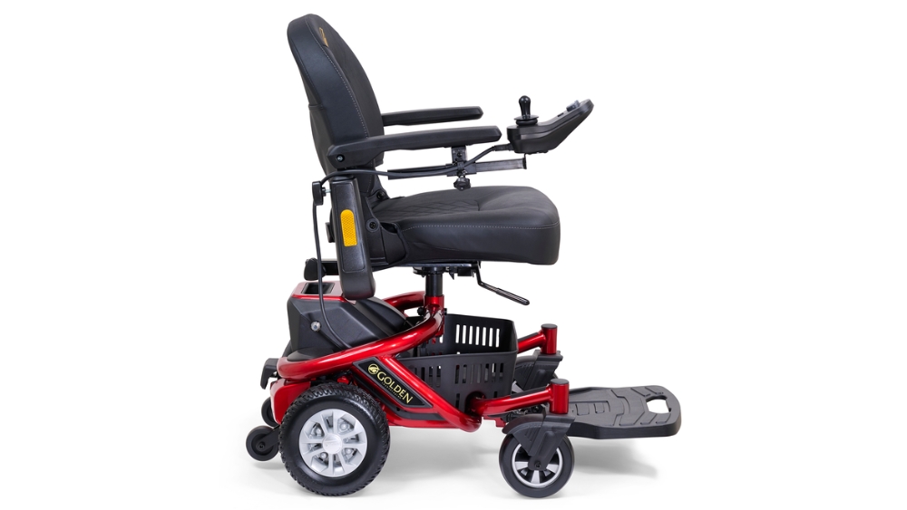 LiteRider Envy Power Wheelchair in red and black with armrests, footrest, and joystick control, shown from the side against a white background.
