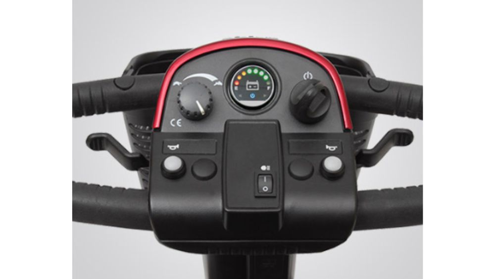 Close-up of the Victory 10 3-Wheel Scooter’s control panel, featuring a speed dial, battery gauge, power switch, horn buttons, and two black handlebars with indicator levers on each side.