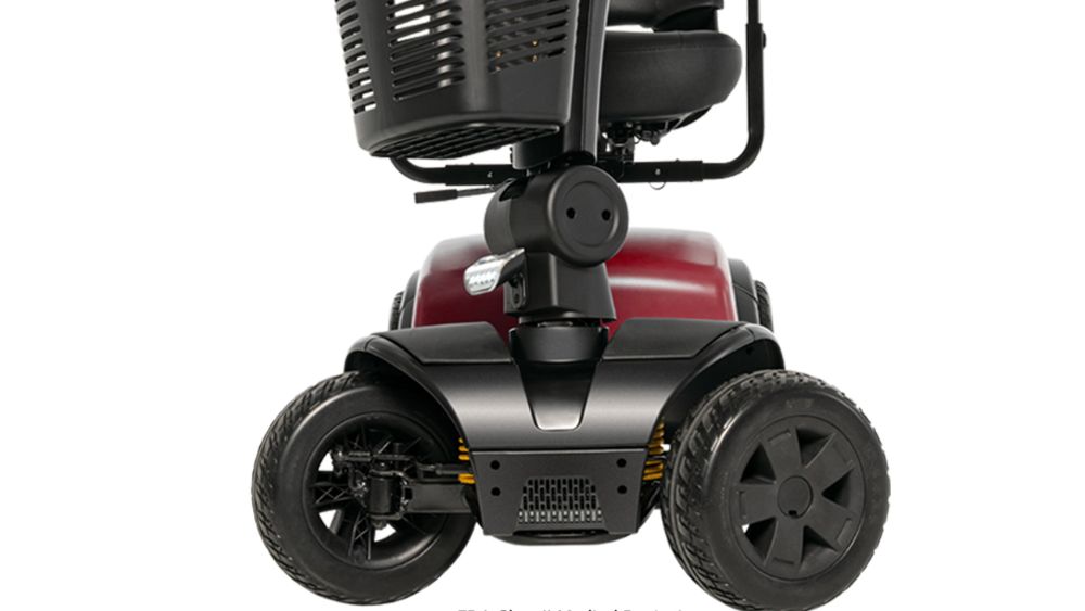 Close-up view of the front section of a red Victory Platinum 4-Wheel Scooter, showing the wheels, lower chassis, and a black storage basket above.
