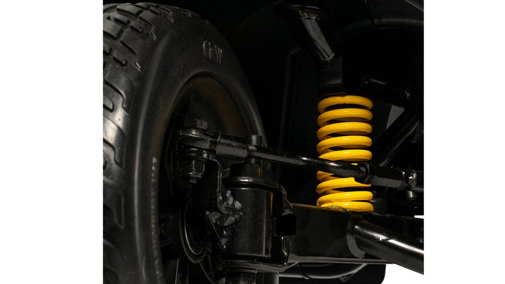 Close-up of the Victory Platinum 4-Wheel Scooter’s suspension system, featuring a yellow coil spring, black shock absorber, and part of the tire.