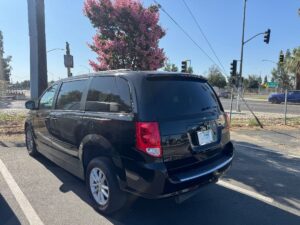 Black Dodge Grand Caravan with Adaptive Vans Side Entry Automatic Fold Out conversion