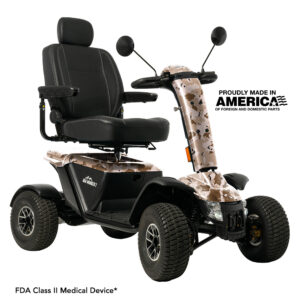 Four-wheel mobility scooter with camouflage detailing, black seat, armrests, and backrest. Text indicates it is made in America and is an FDA Class II medical device.