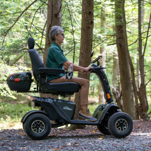 A person navigating the forest trail on a Baja™ Wrangler® 2 4-Wheel Scooter, surrounded by towering trees.