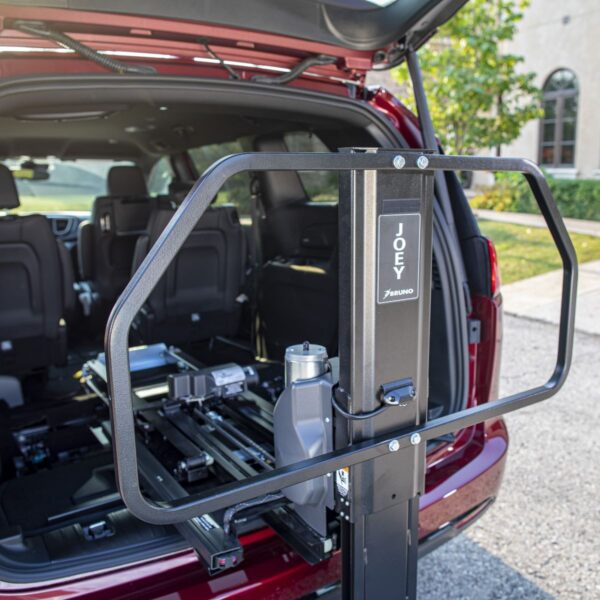A Bruno Joey Platform Style Interior Lift (VSL-4400) is installed in the rear of a red SUV with its hatch open in a parking lot.