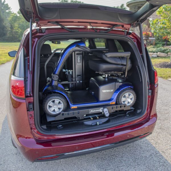 A mobility scooter is loaded into the trunk of a red minivan on a driveway using the Bruno Joey Platform Style Interior Lift (VSL-4400).