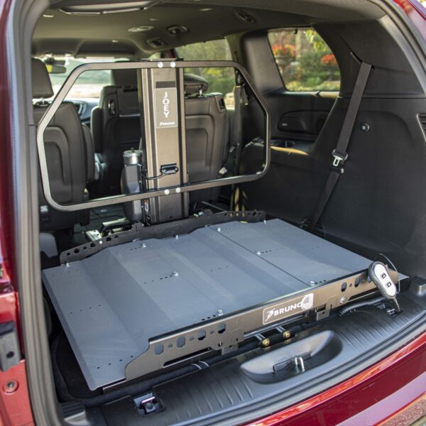 A vehicle interior with rear seats folded down, featuring the Bruno Joey Platform Style Interior Lift (VSL-4400)—a motorized platform for transporting a wheelchair or mobility scooter.
