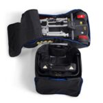The Buzzaround CarryOn (GB120) electric wheelchair is neatly folded, contained within a partially unzipped black Travel Bag, showcasing the main body and wheels.