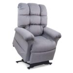 The Cloud Lift Chair is a gray upholstered recliner inspired by the EZ Sleeper with Twilight, featuring padded armrests and backrest, set on a partially elevated mechanical base for enhanced comfort.
