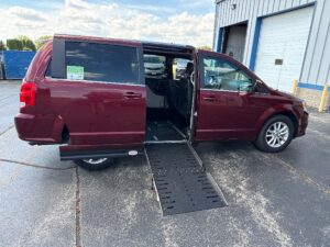 Red Dodge Grand Caravan with Adaptive Vans Side Entry Automatic Fold Out conversion