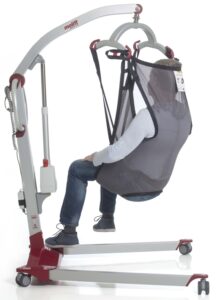 Person seated in a Molift EvoSling Shadow, supported by an overhead hoist, on a white background.