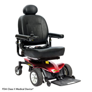 The Jazzy Elite ES Power Wheelchair is a black and red electric wheelchair featuring a padded seat, armrests, footrest, control joystick, four wheels, and an FDA Class II Medical Device label.