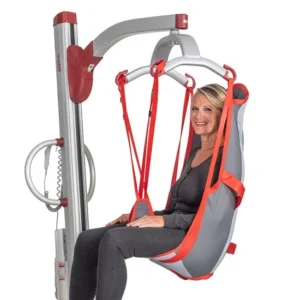 A woman smiling in a gray and red lift chair, seamlessly integrated with the Molift Partner 255, embodies comfort and style in her gray outfit—highlighting the lift's innovative design.