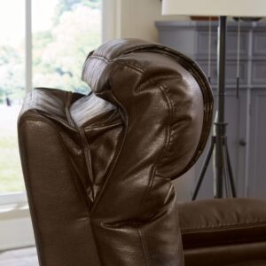 Close-up of the backrest and arm of the Rhea Lift Chair in dark brown leather, with a window and gray cabinet visible in the background.