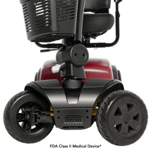 Close-up view of a mobility scooters front section showing two wheels, a red chassis, and part of the seat. Text indicates it is an FDA Class II Medical Device.