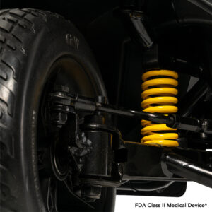 Close-up view of a vehicle suspension system with a yellow coil spring and black components. Text reads: FDA Class II Medical Device.